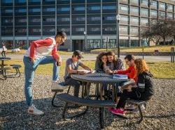 Students sitting outside of Blanton Hall having a conversation with one another.